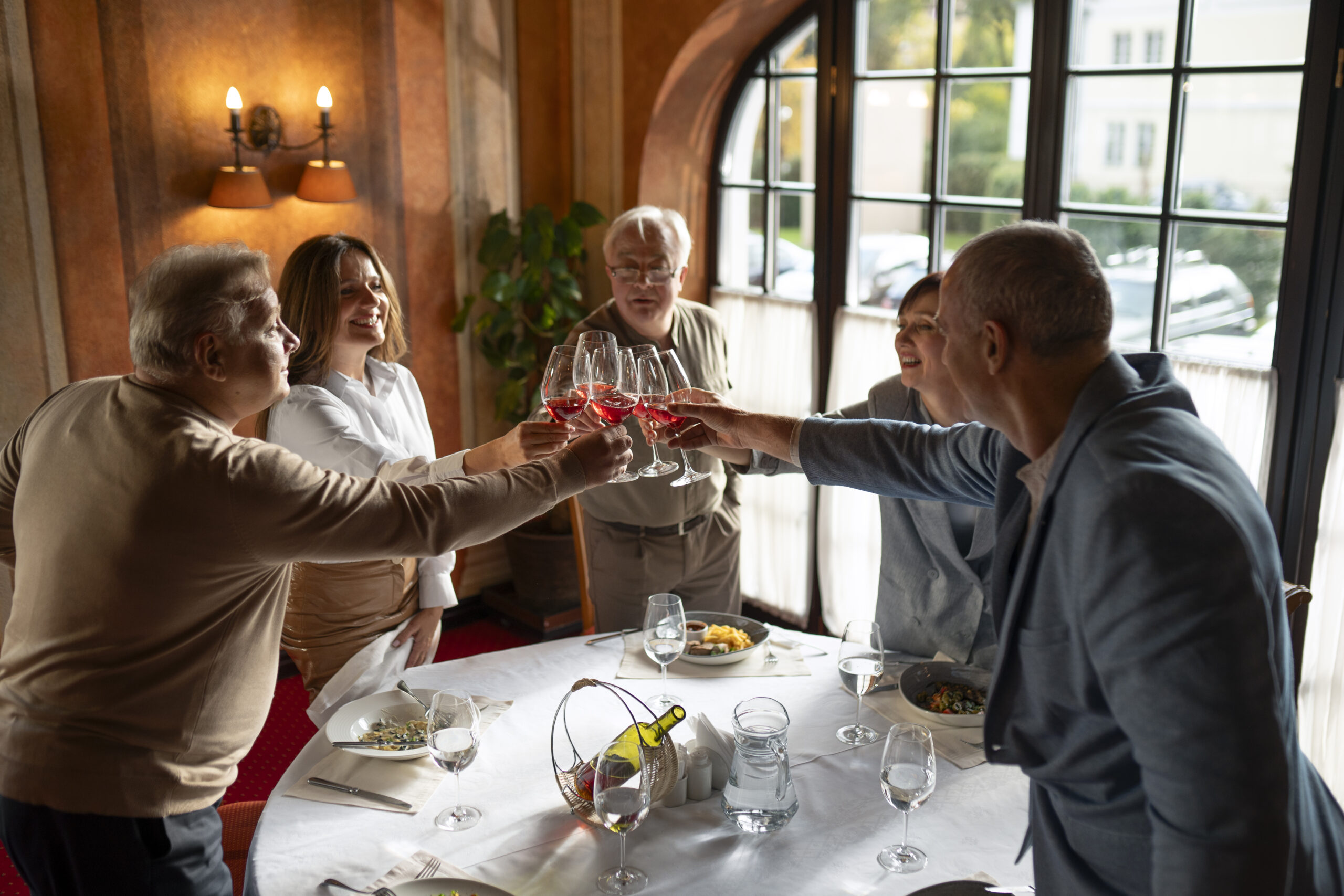 Groupe de retraités réuni autour d’un repas convivial dans le restaurant d’un hôtel.